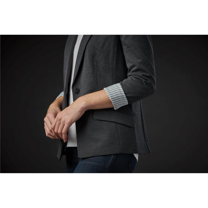 A women's grey knit blazer with rolled sleeves and a pocket, featuring a subtle branding logo.