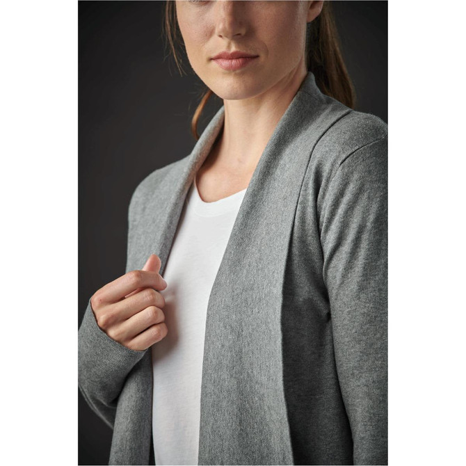 A grey women's cardigan with a shawl collar, displayed on a model wearing a white top. The image has a subtle dark background.