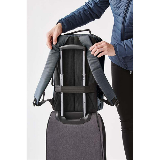 A grey Hedmark Commuter Backpack with padded straps being attached to a suitcase for easy transport.