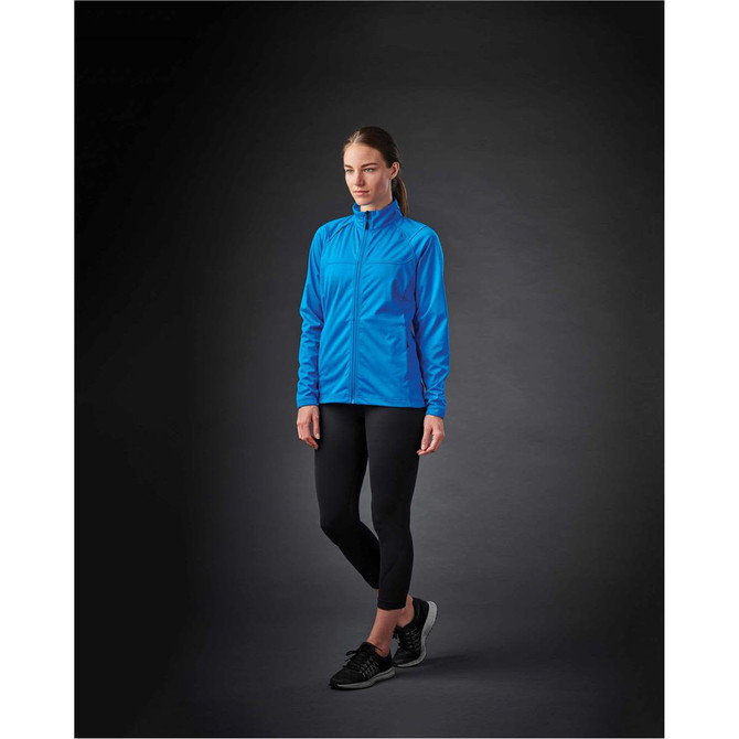 A blue women's lightweight softshell jacket is displayed on a model against a dark background, showcasing its sleek design.