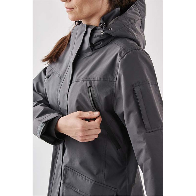 A women's grey 5-in-1 system jacket featuring a hood and zippered pocket. The jacket has a subtle branding logo.