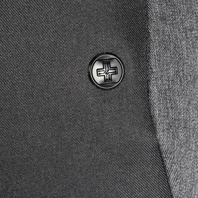 A close-up of a black button on a grey fabric, featuring a simple embossed design.