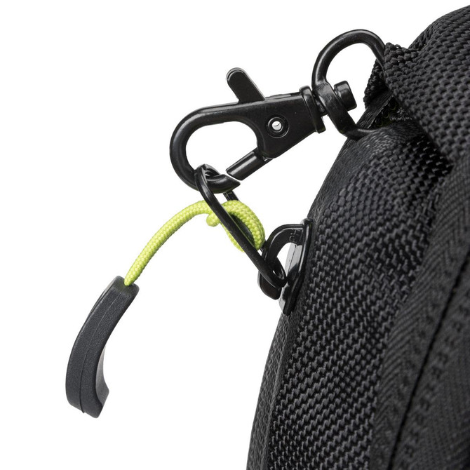 A close-up of a black backpack with a green accent on the zipper pull and a metal clip.