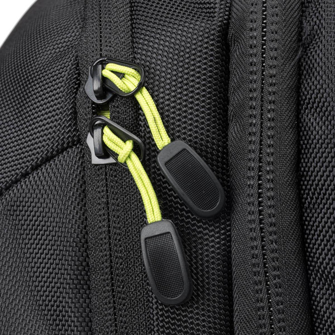 Close-up of a black backpack zipper with bright green pulls, showcasing the textured fabric.