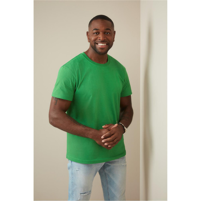 Men's heavyweight green crew neck T-shirt displayed by a smiling man, featuring a logo on the shirt.