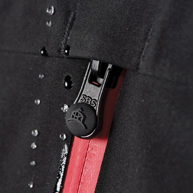 A close-up of a black softshell jacket featuring a zip with a red lining and a logo on the zipper pull.