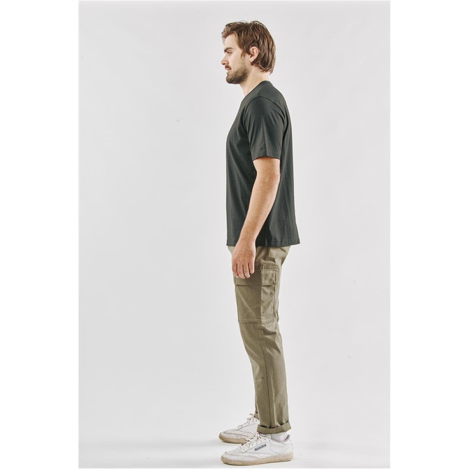 A side view of a man wearing a black Men's Settebello Tee paired with olive green cargo pants and white sneakers.