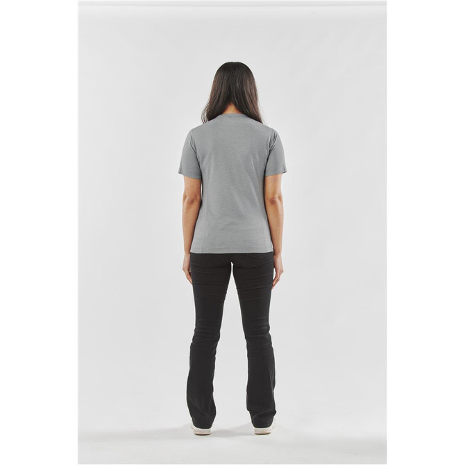 A woman stands with her back to the camera, wearing a grey Women's Volante H2X-Dry Tee and black pants.