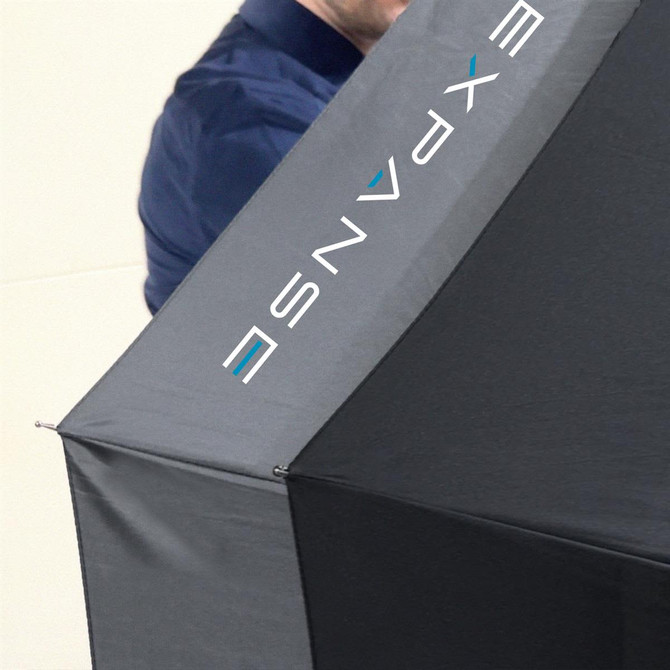 A black umbrella with a branded logo, featuring a sleek, modern design, partially open and held by a person.
