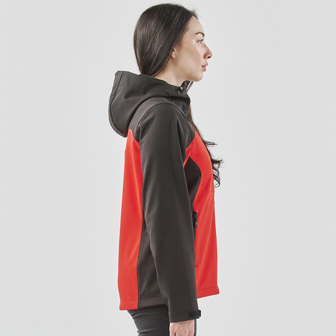 A women's softshell jacket in red and black, featuring a hood and zippered pockets, displayed from the side.