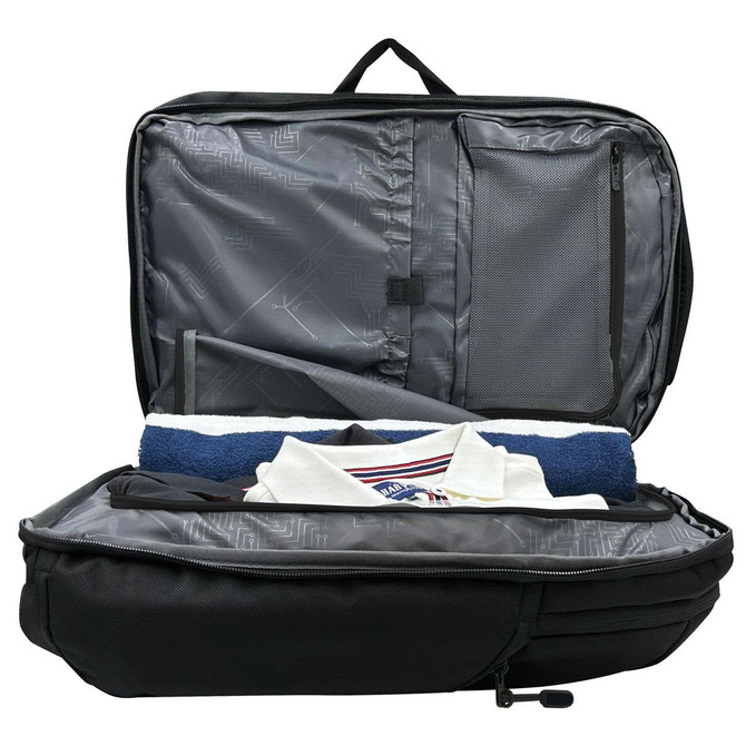 A black backpack with an open interior, featuring grey lining and neatly arranged items including a towel and a shirt.