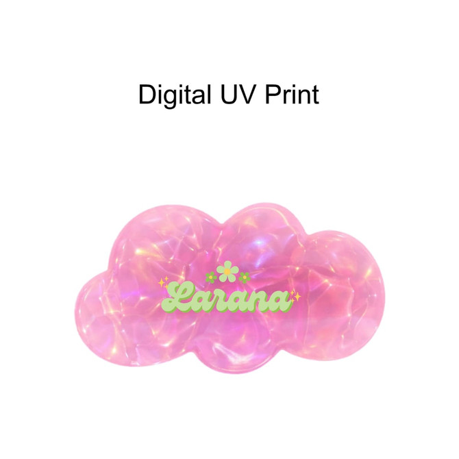 A pink iridescent alligator hair clip in a cloud shape with a logo. Features a digital UV print design.