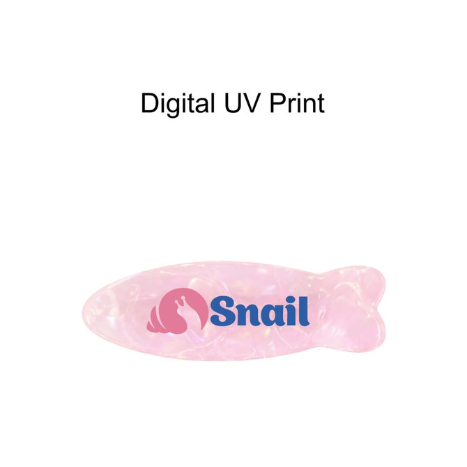 A fish-shaped hair clip in iridescent pink, featuring a logo in blue.