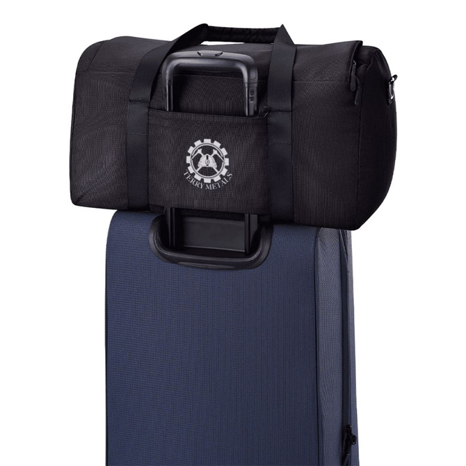 A black duffel bag positioned on top of a blue suitcase, featuring a logo on the front.