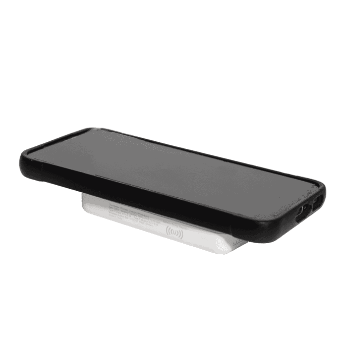 A wireless charging power bank in white with a sleek design supporting a black smartphone on top.