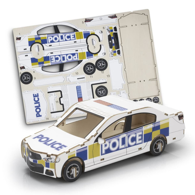 A model car in white with blue and yellow police markings, alongside its cardboard assembly sheet.
