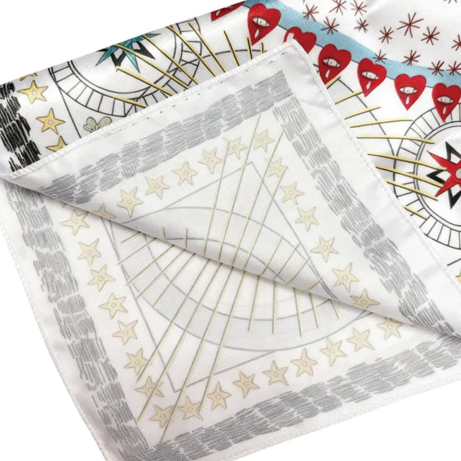 A silk satin scarf featuring a vibrant design with red hearts and star patterns on a white background.