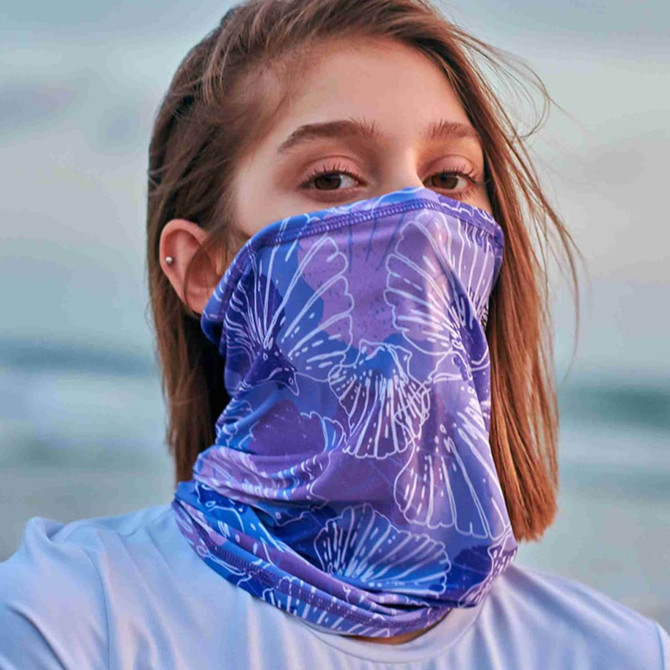 A purple bandana with a floral pattern, worn as a face covering by a person. It features a branding logo.