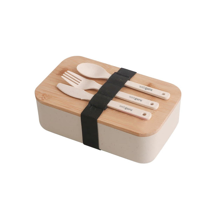 A lunch box in cream colour with a bamboo cover, secured by a black strap, accompanied by cutlery.