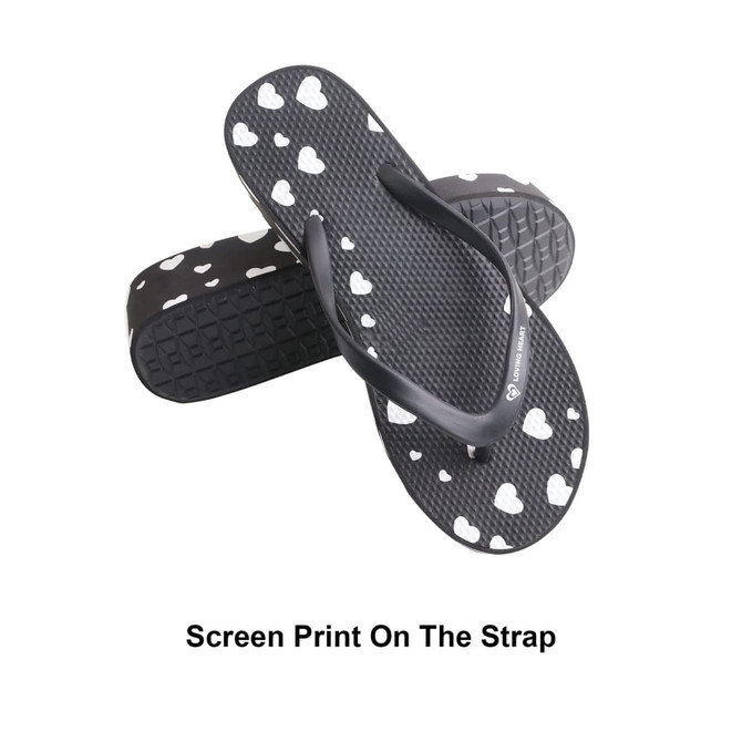 Classic black thongs featuring a heart print on the strap and a textured sole. Includes a logo on the side.
