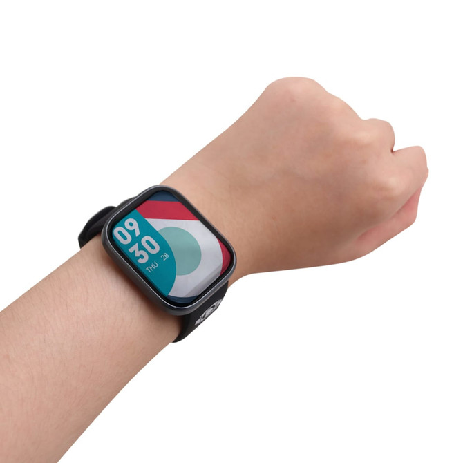 A black square smartwatch on a wrist, featuring a vibrant, multicoloured display of the time and date.