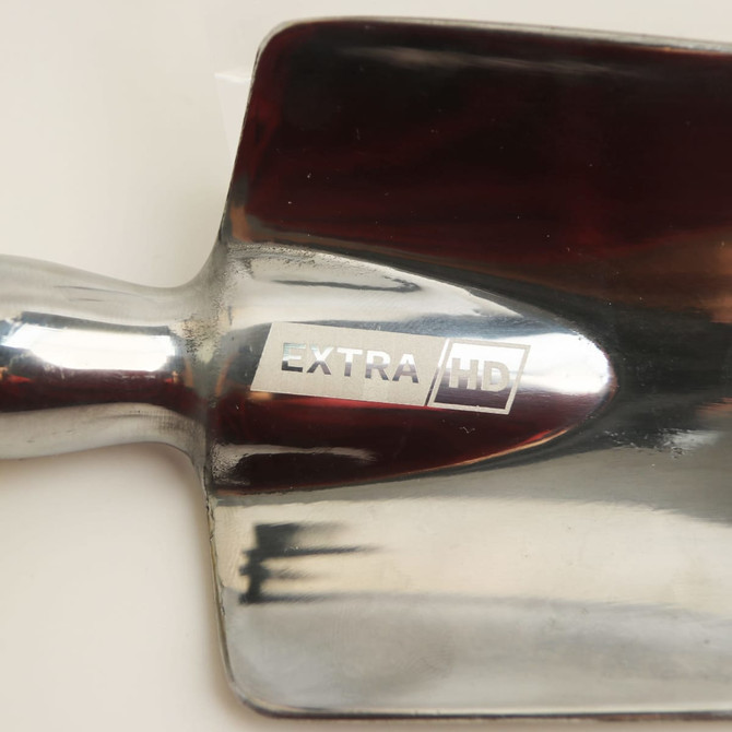A shiny metal garden spade with a reflective surface and a sturdy handle. It features a logo on the blade.