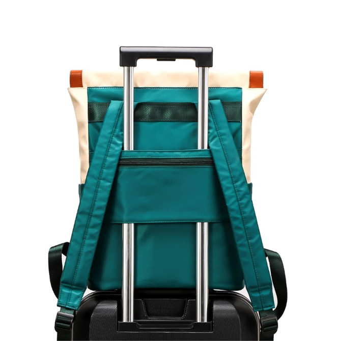 A teal convertible nylon backpack with adjustable straps, resting on a black suitcase. Features include a zippered pocket and a logo.