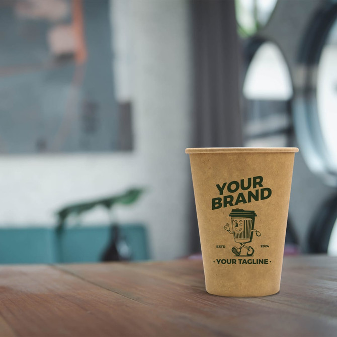 A kraft paper cup in light brown with a logo, placed on a wooden table in a modern setting.