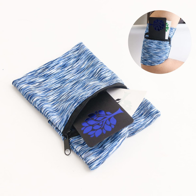 A blue and white patterned mini wearable wallet with a zippered pocket and a card visible inside.