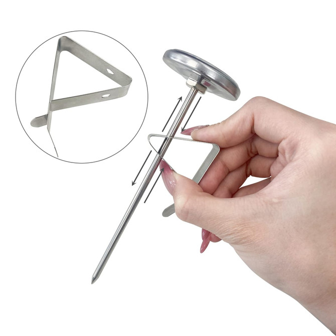 A stainless steel instant read dial thermometer being held, featuring a circular dial and a triangular probe.