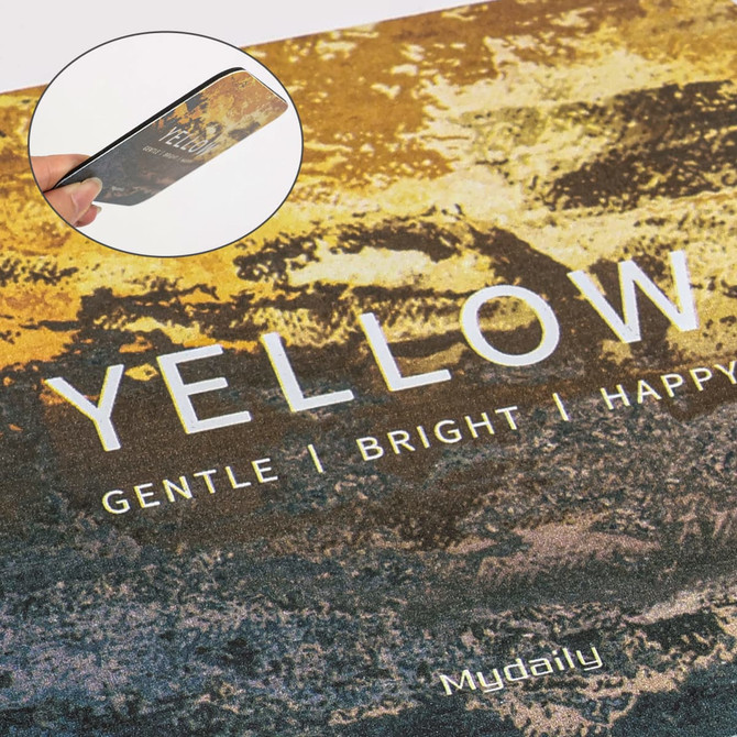 A frosted metal coaster in yellow shades with a textured design and a small inset showcasing its surface detail.