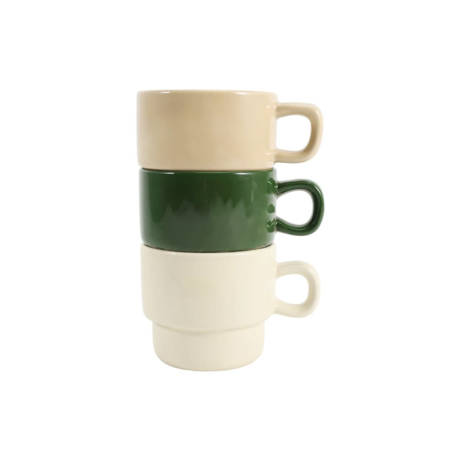 Stackable ceramic mugs in beige, green, and off-white, arranged in a neat stack. The mugs have handles and a smooth finish.