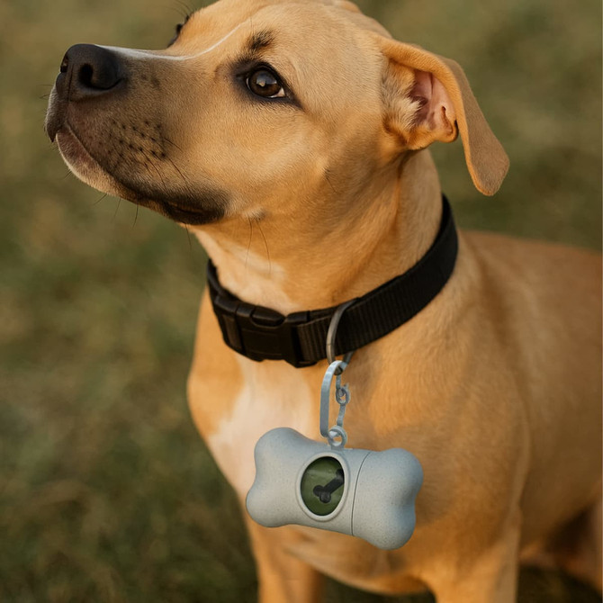 A bone-shaped pet waste bag dispenser in grey, attached to a dog's collar, with a green logo visible.
