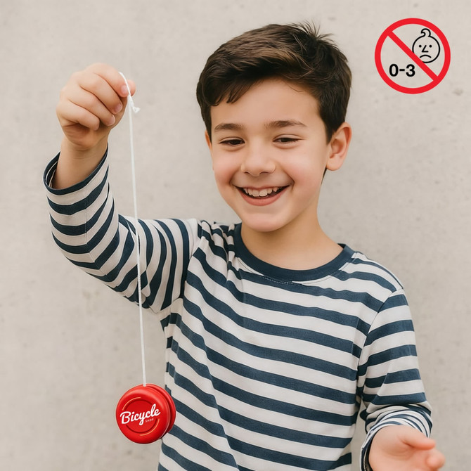 A wooden yoyo in vibrant red, held by a smiling child wearing a striped shirt, with a logo visible.