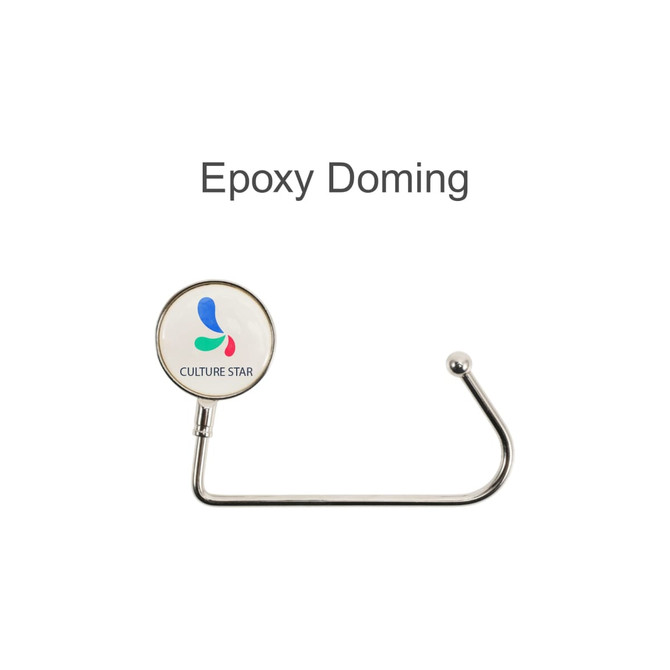 A round silver desk hook with a glossy white circular end featuring a logo with blue and green accents.