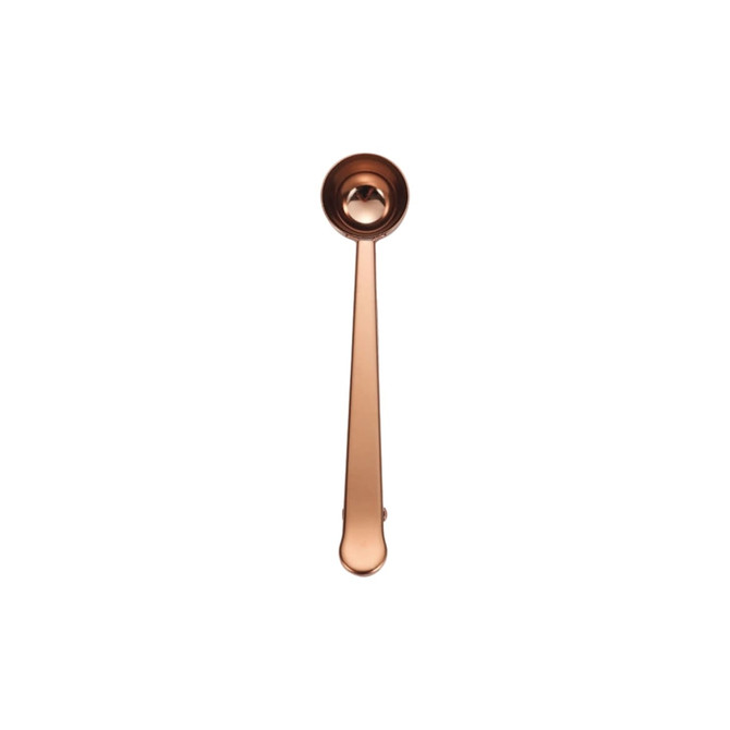 A copper coffee measuring spoon with a clip, featuring a long handle and a rounded scoop at the end.