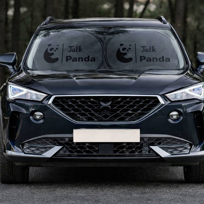 Twin circular black car sun shades displayed on the front windshield of a black SUV, featuring a logo.