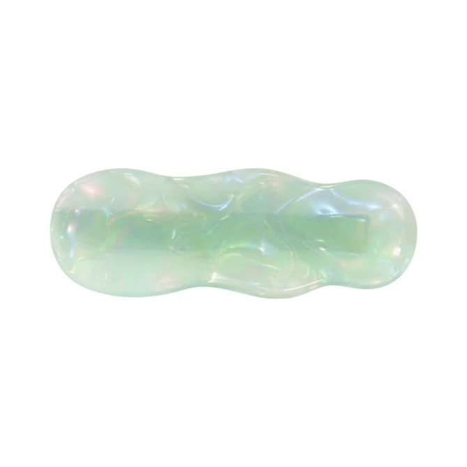 A ripple iridescent alligator hair clip in soft green tones with a glossy, wavy design and a logo.