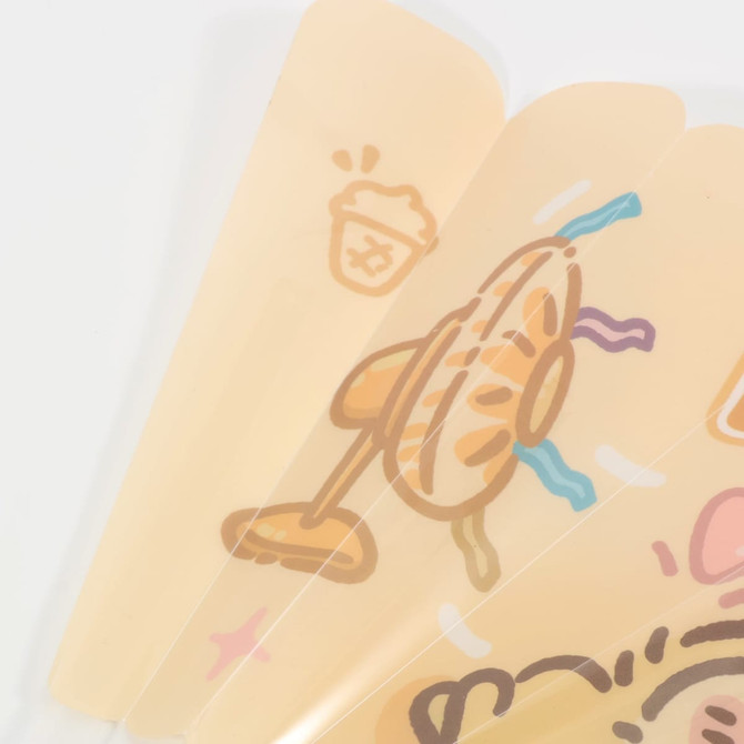 A plastic hand fan with a translucent yellow colour and playful designs, including food and drink illustrations.