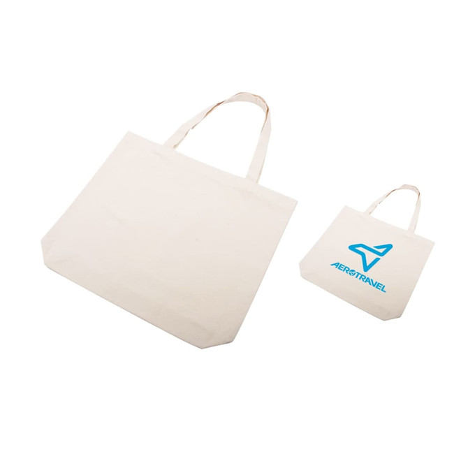 A natural cotton tote bag in a light cream colour, featuring an icon and branding. Two sizes are displayed.