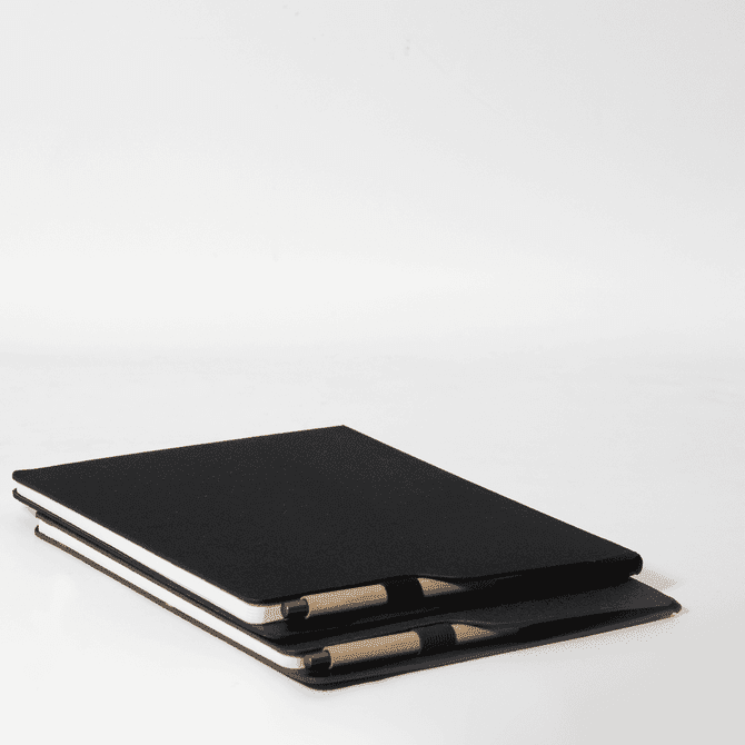 A black A4 notebook stacked with a pen, featuring a simple design and a logo on the cover.
