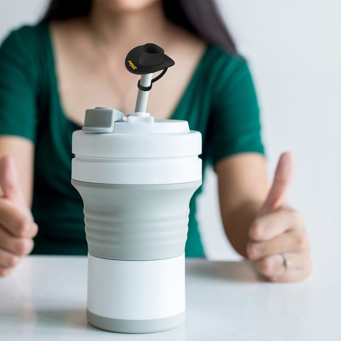 A drink bottle with a grey and white design topped with a black cowboy hat silicone straw cover.