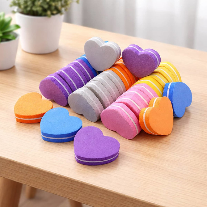 A pack of 50 heart-shaped nail files in various colours, including purple, pink, orange, and blue, displayed on a table.