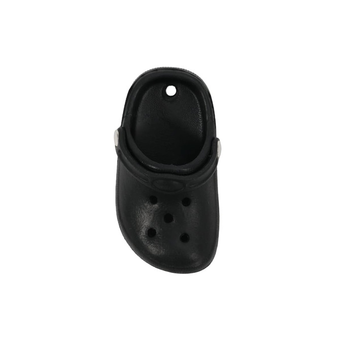 A black clog shoe fridge magnet featuring ventilation holes and a strap, with a circular hole at the top.