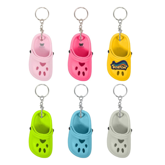 A keyring featuring mini clog shoes in pink, yellow, green, blue, and grey, with a logo on one.