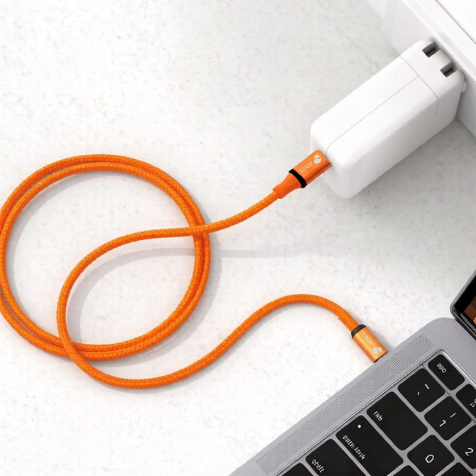 An orange 100W magnetic flat braided charging cable connected to a white charger and a laptop.