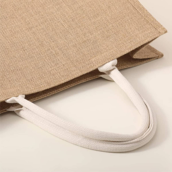 A beige tote bag with white rope handles, featuring a textured fabric finish.