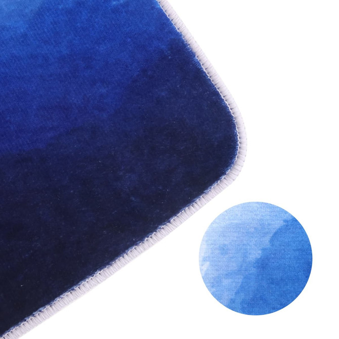 A flannel logo mat featuring a gradient of deep blue tones, with a close-up of its texture and stitching.