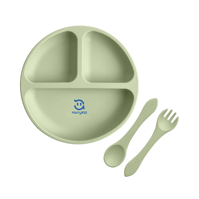 A green silicone kids suction plate featuring three sections, accompanied by a spoon and fork, with a logo.