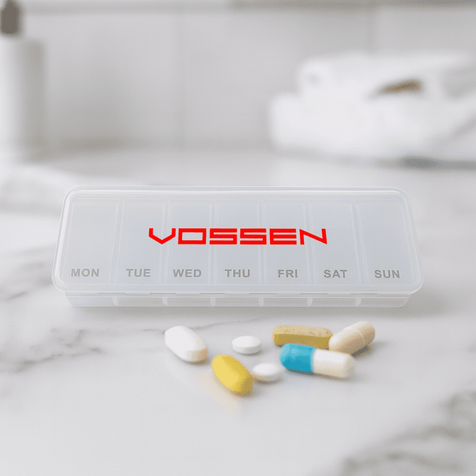 A transparent pill box with compartments for each day of the week, featuring various coloured pills beside it. It has a logo.